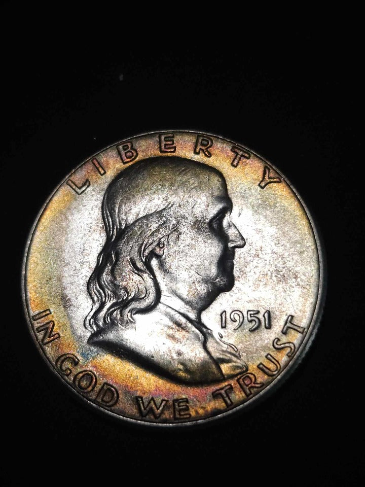 obverse of 1951 franklin toned with red black and greenish blue hues